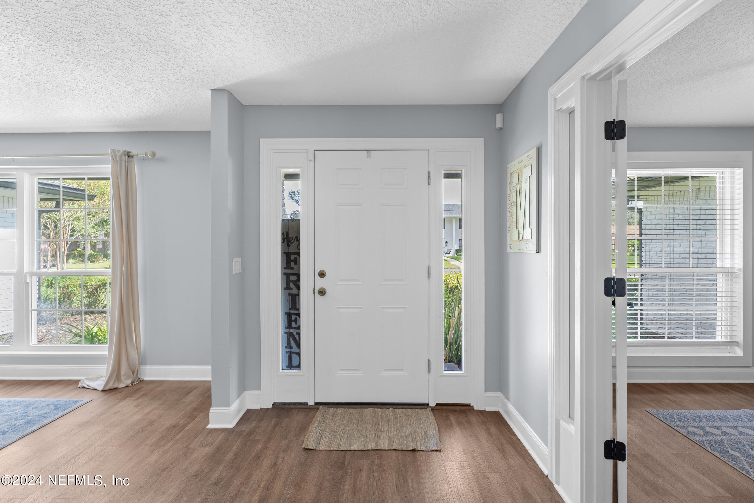 9448 Wexford Road Jacksonville, FL 32257 - Photo 4 of 27 an empty room with wooden floor and windows
