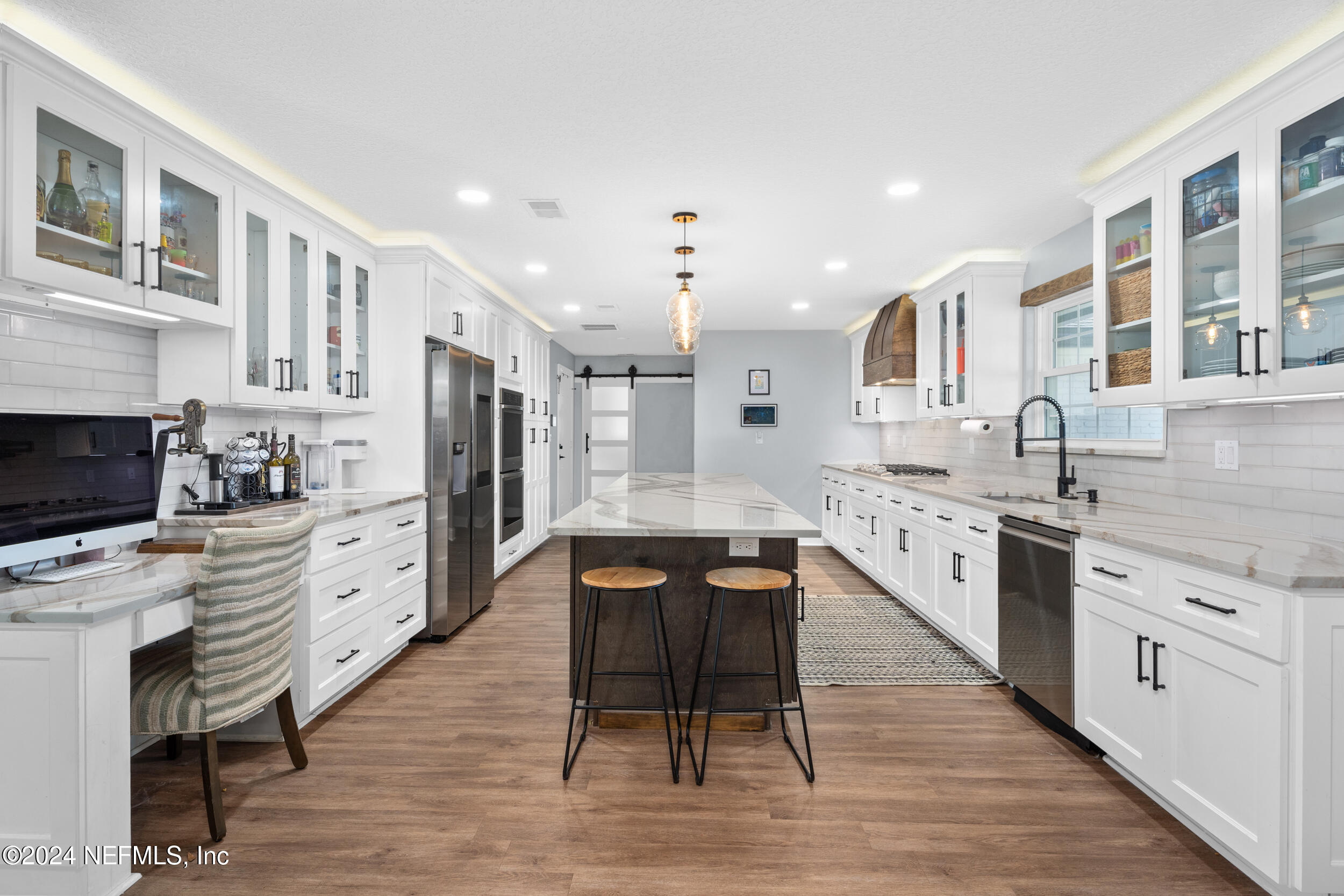 9448 Wexford Road Jacksonville, FL 32257 - Photo 5 of 27 a large kitchen with stainless steel appliances kitchen island granite countertop a stove top oven a sink dishwasher a dining table and chairs with wooden floor