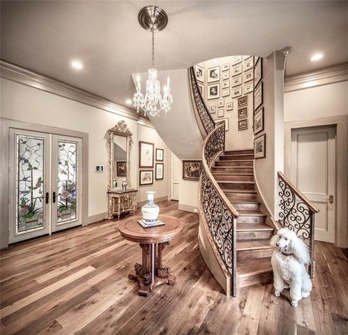 a view of a livingroom with furniture wooden floor chandelier and windows
