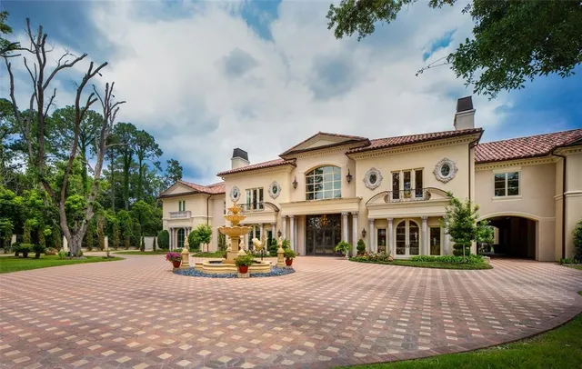 a view of a white house with a yard and table and chairs under an umbrella