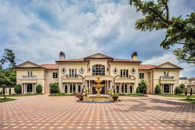 a view of a white house with a bench in front of it