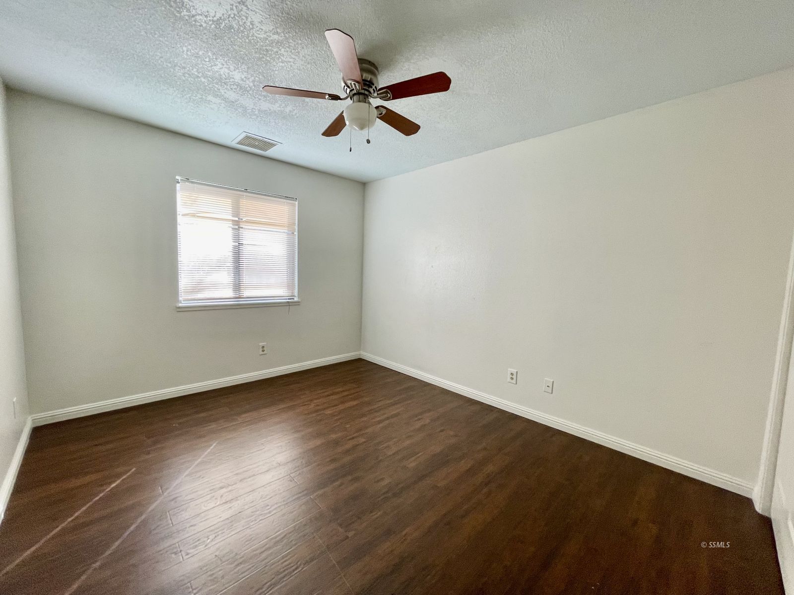 225 Michele Street Ridgecrest, CA 93555 - Photo 20 of 36 an empty room with wooden floor fan and windows