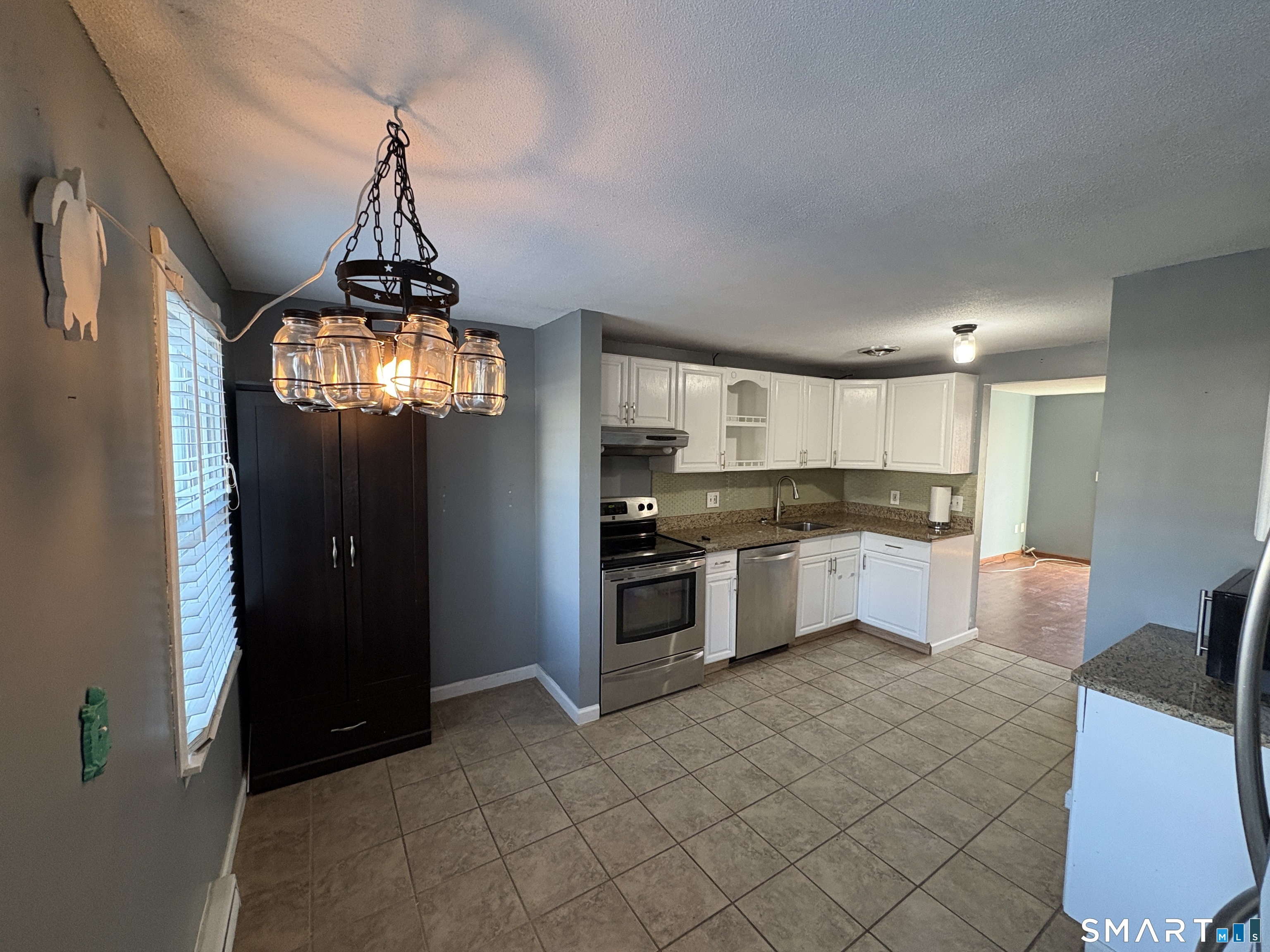 13 Lakeside Drive, Unit M Ledyard, CT 06339 - Photo 5 of 16 a kitchen with stainless steel appliances granite countertop a refrigerator and a stove top oven
