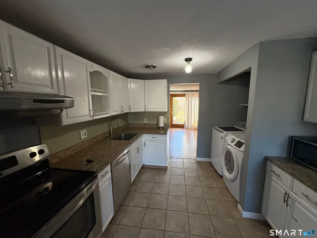 a kitchen with a sink a stove and cabinets