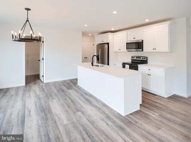 a large white kitchen with wooden floor