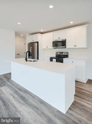 a kitchen with stainless steel appliances a refrigerator sink and microwave