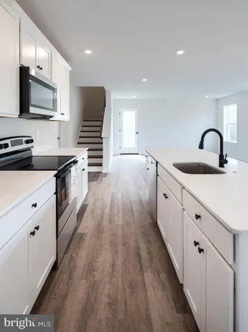 a kitchen with granite countertop a sink and steel appliances