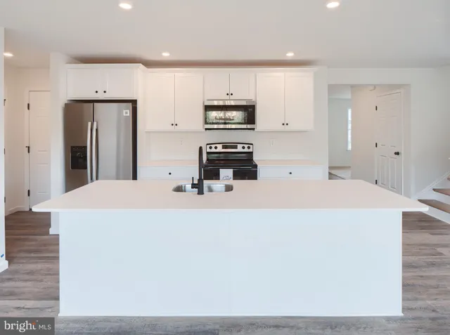 a kitchen with stainless steel appliances a refrigerator and a stove top oven