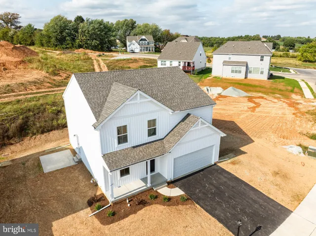 a view of a house with big yard and large windows