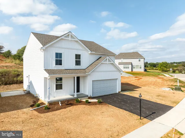 a view of a white house with a yard and potted plants