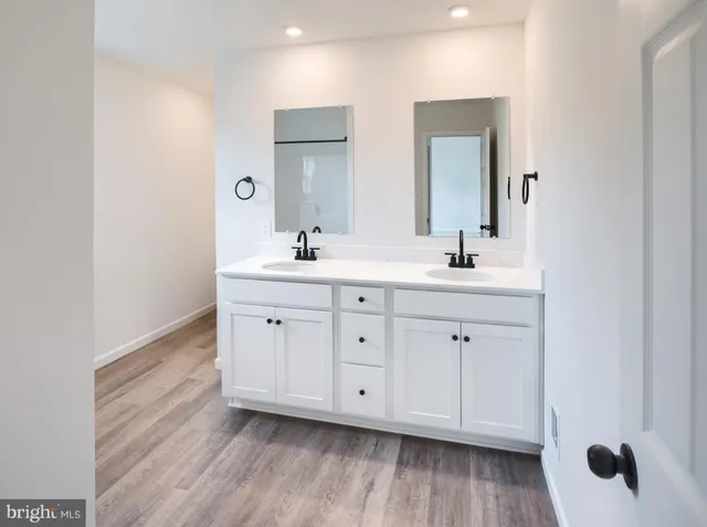 a spacious bathroom with double vanity sink a mirror and window