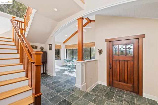 a dining room with furniture and large windows