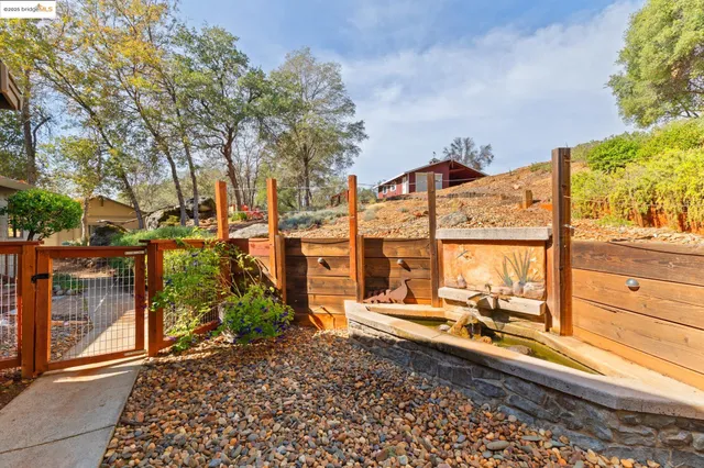 an aerial view of residential house with outdoor space and covered with trees
