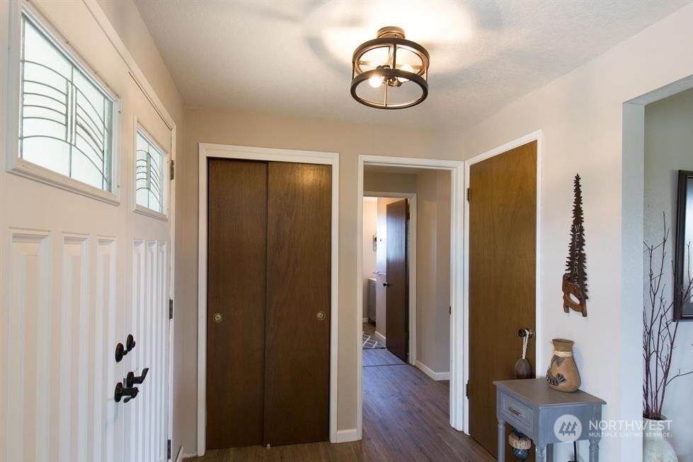 819 North Kendall Road Sequim, WA 98382 - Photo 31 of 40 a view of a hallway with wooden floor and chandelier