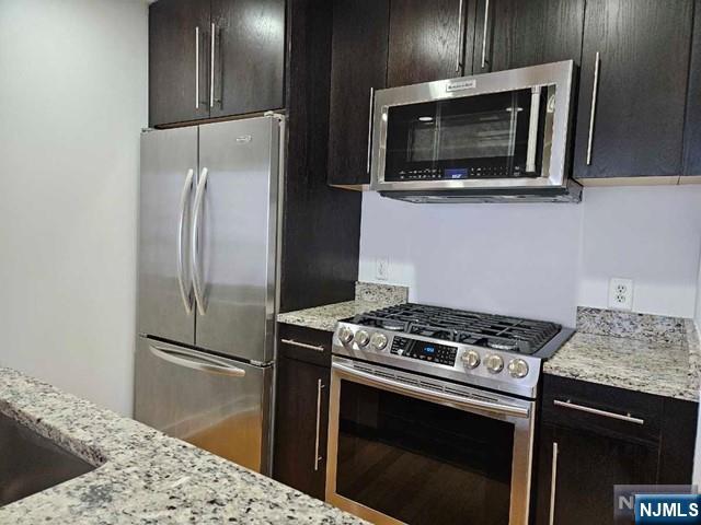 807 Hudson Park Edgewater, NJ 07020 - Photo 3 of 27 a kitchen with stainless steel appliances granite countertop a stove microwave and refrigerator