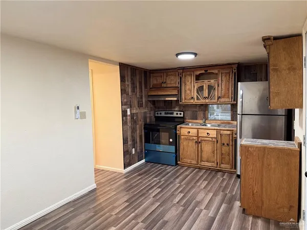 a kitchen with a refrigerator and a stove top oven
