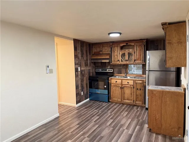 a kitchen with a refrigerator and a stove top oven