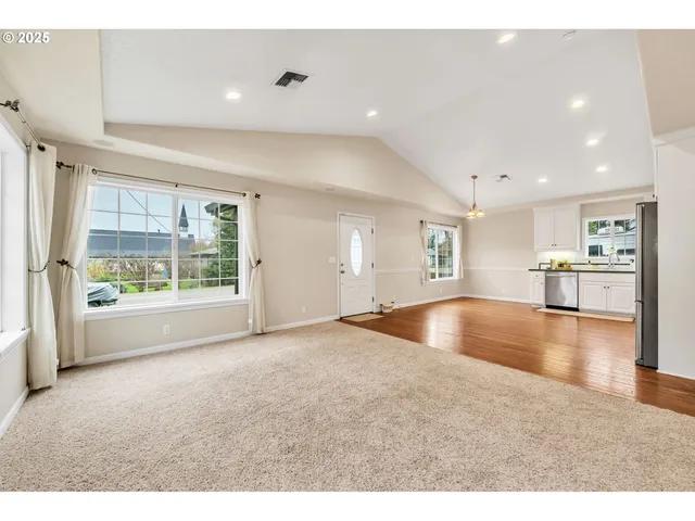 a view of empty room with wooden floor and floor to ceiling window