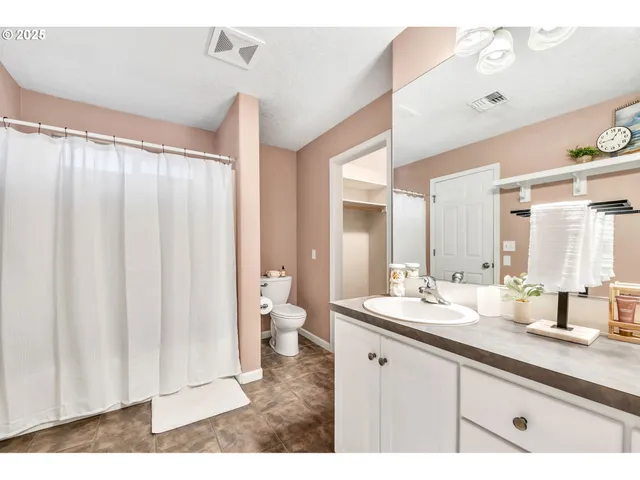 a bathroom with a double vanity sink mirror and toilet