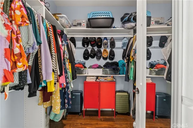 a view of walk in closet with clothes and shoes