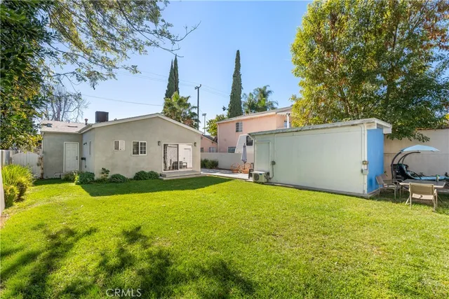 a view of a house with backyard and a tree