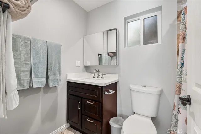 a bathroom with a sink toilet vanity and shower