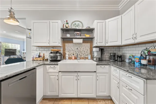 a kitchen with white cabinets and sink
