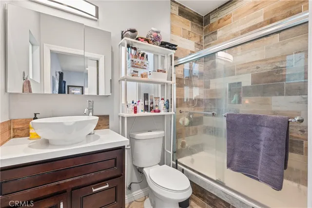 a bathroom with a sink a toilet and shower