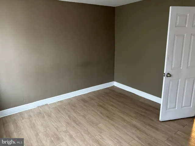 an empty room with wooden floor and door