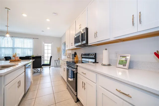 a kitchen with stainless steel appliances granite countertop a sink and dishwasher a stove top oven with white cabinets