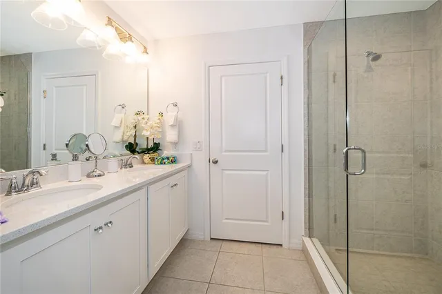 a spacious bathroom with a granite countertop sink a mirror and shower