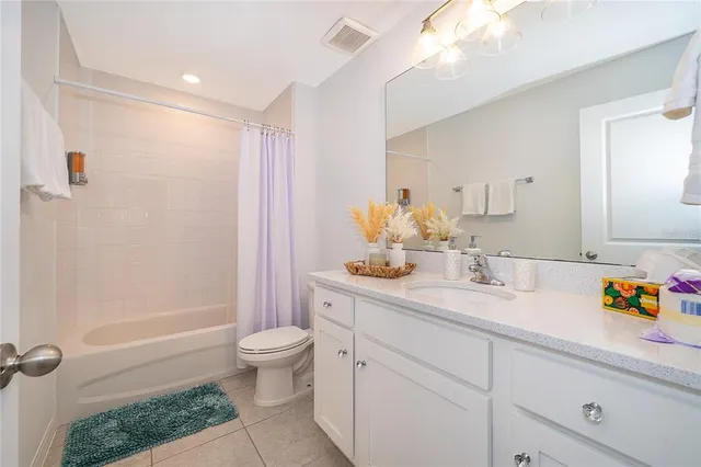 a bathroom with a granite countertop sink a toilet a mirror and shower