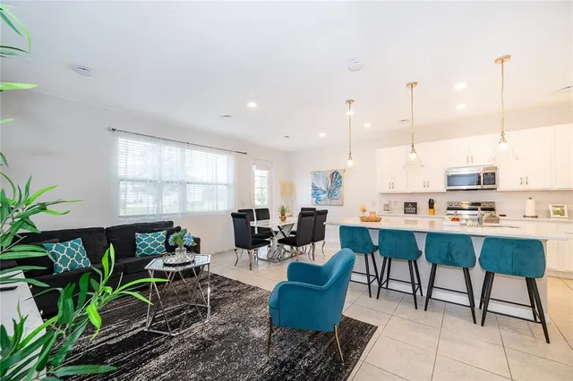 a living room with lots of furniture and a potted plant