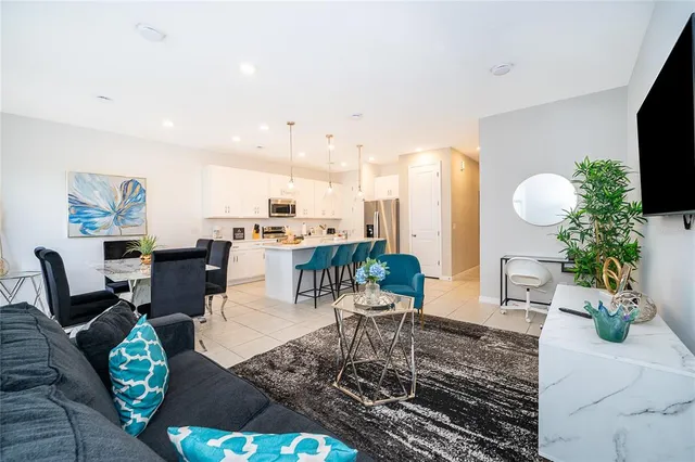 a living room with furniture wooden floor and a kitchen view