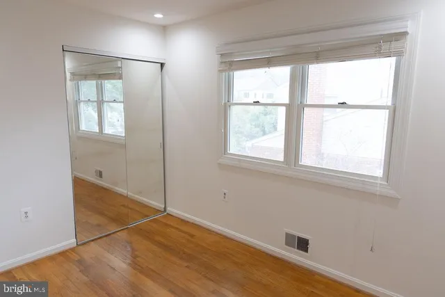 a bathroom with a granite countertop toilet a sink a vanity and a window