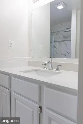 an empty room with wooden floor fireplace and windows