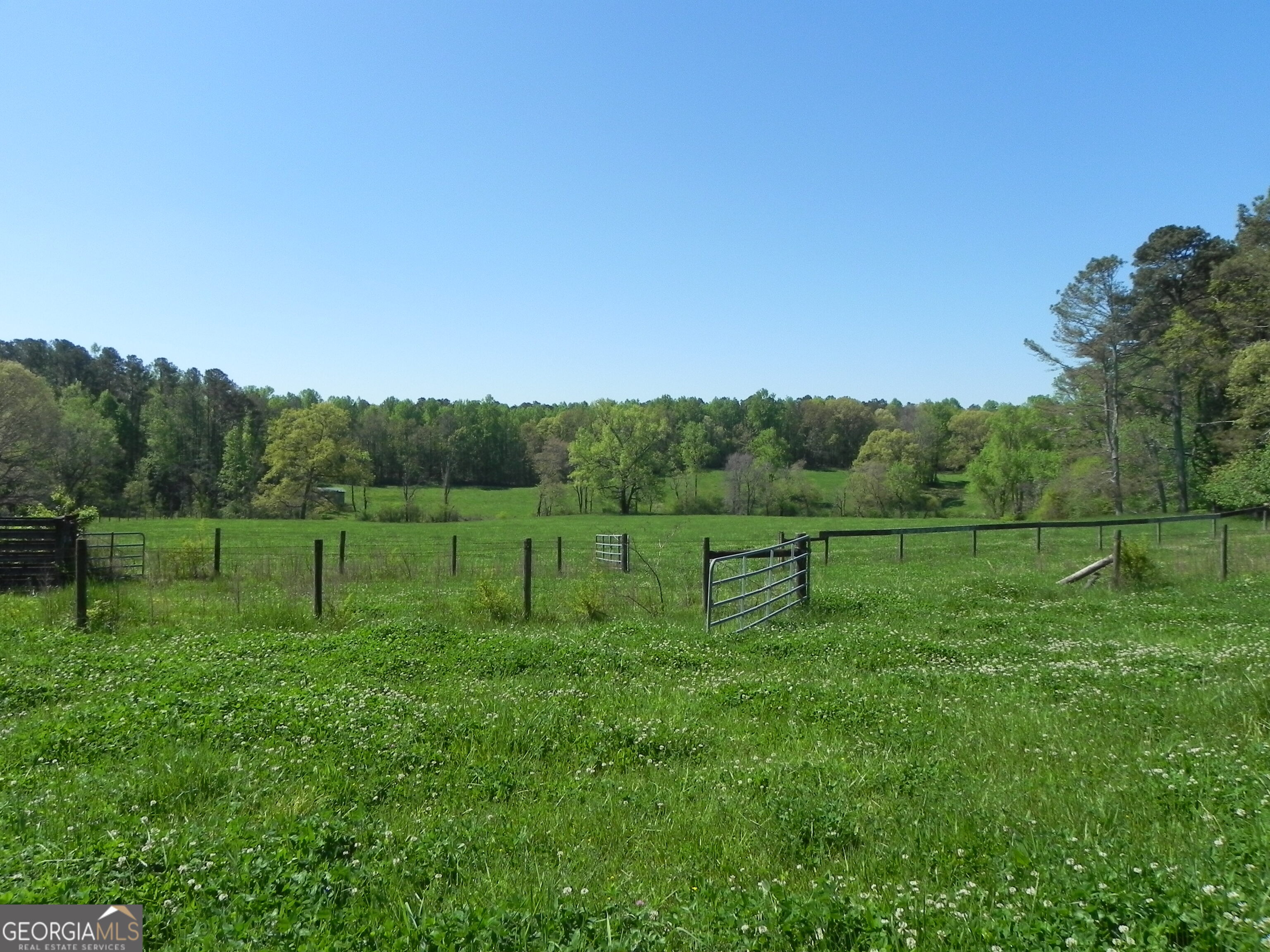 a view of a green field with wooden fence