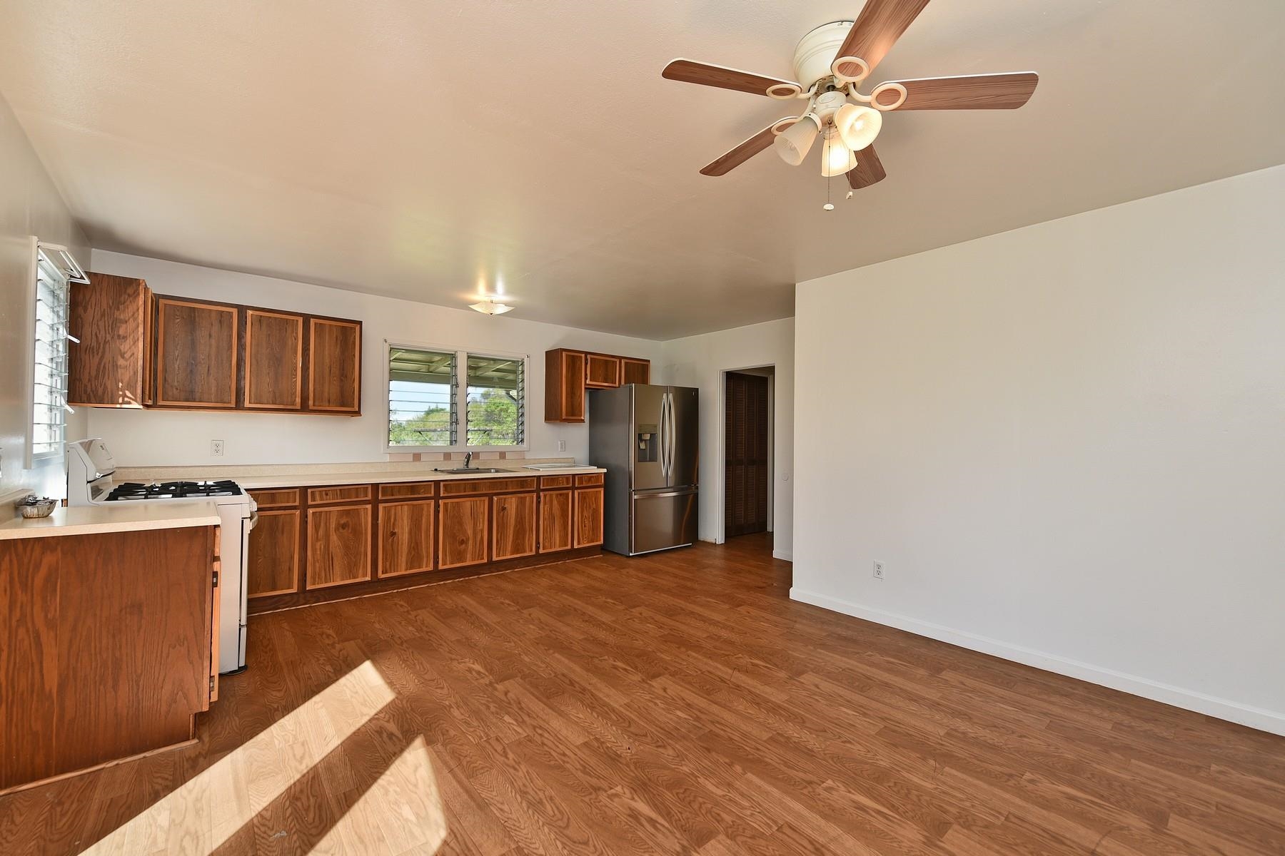 1145 Olinda Road Makawao, HI 96768 - Photo 24 of 30 a large kitchen with stainless steel appliances granite countertop a stove cabinets and wooden floor