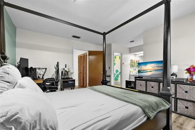 a bedroom with a bed and a dresser with mirror
