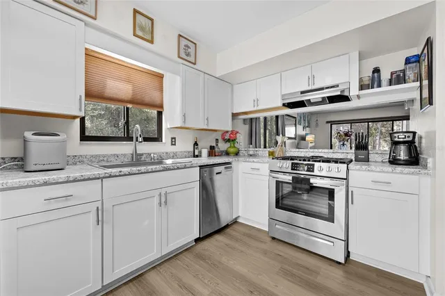 a kitchen with granite countertop white cabinets and white appliances