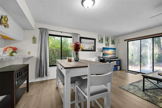 a kitchen with a table chairs microwave and cabinets