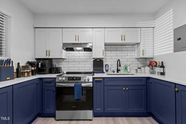 a kitchen with stainless steel appliances granite countertop a stove a sink and a refrigerator