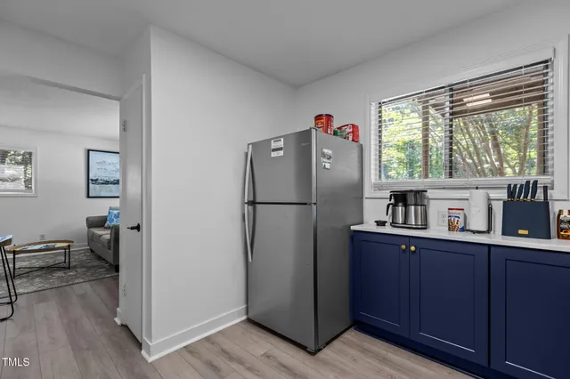 a kitchen with stainless steel appliances a refrigerator cabinets and wooden floor