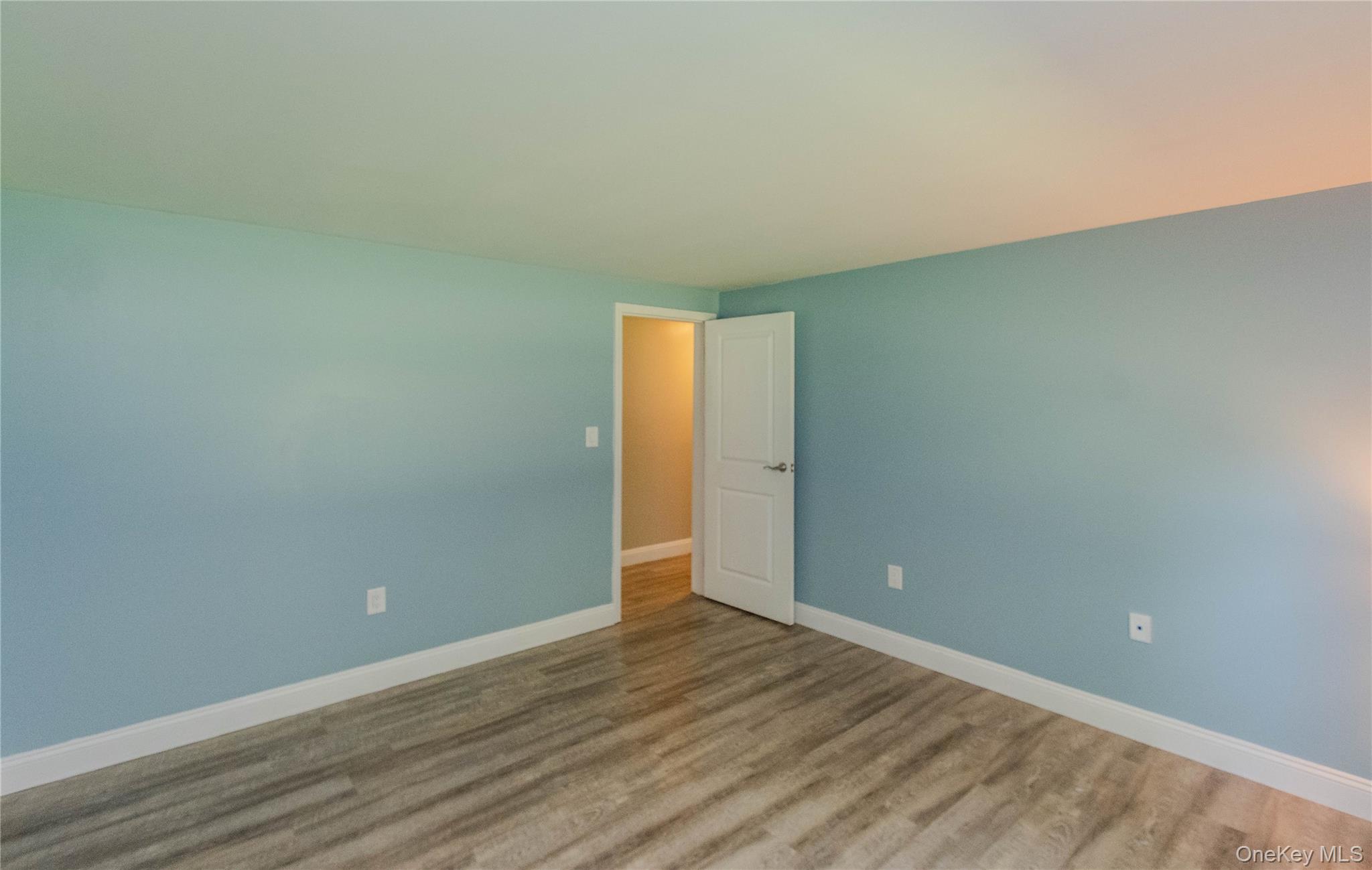 15 Van Dewark Road Middletown, NY 10941 - Photo 19 of 41 Interior space featuring wood-finish flooring, light blue wall paint, white baseboards, and a white interior door