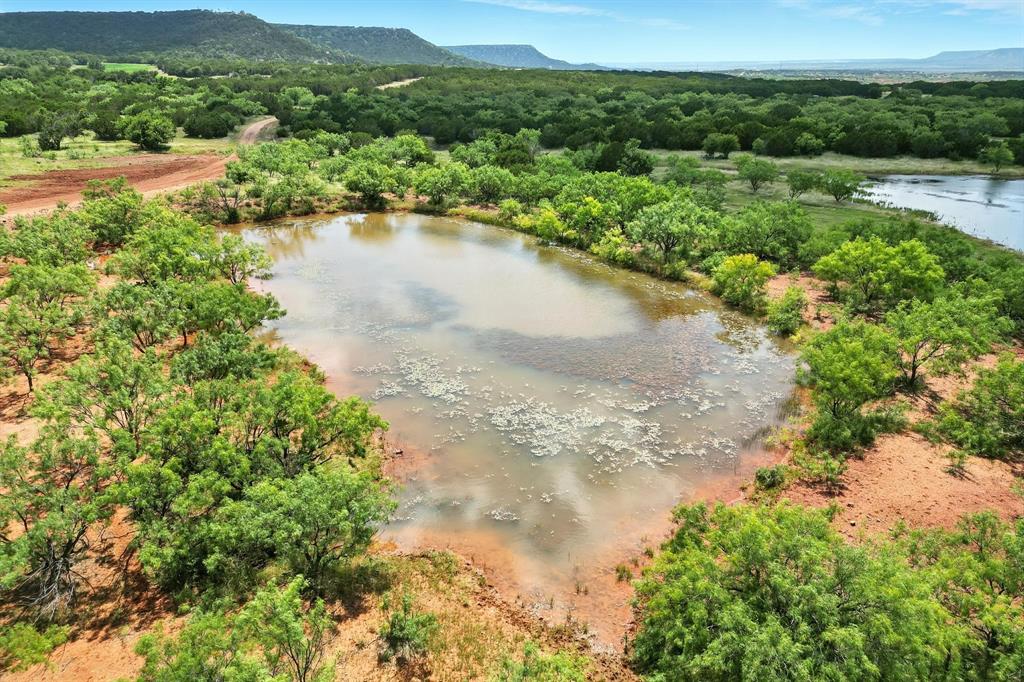 635 County Road 184 Winters, TX 79567 - Photo 29 of 40 Aerial view of a water and mountain view and a heavily wooded area