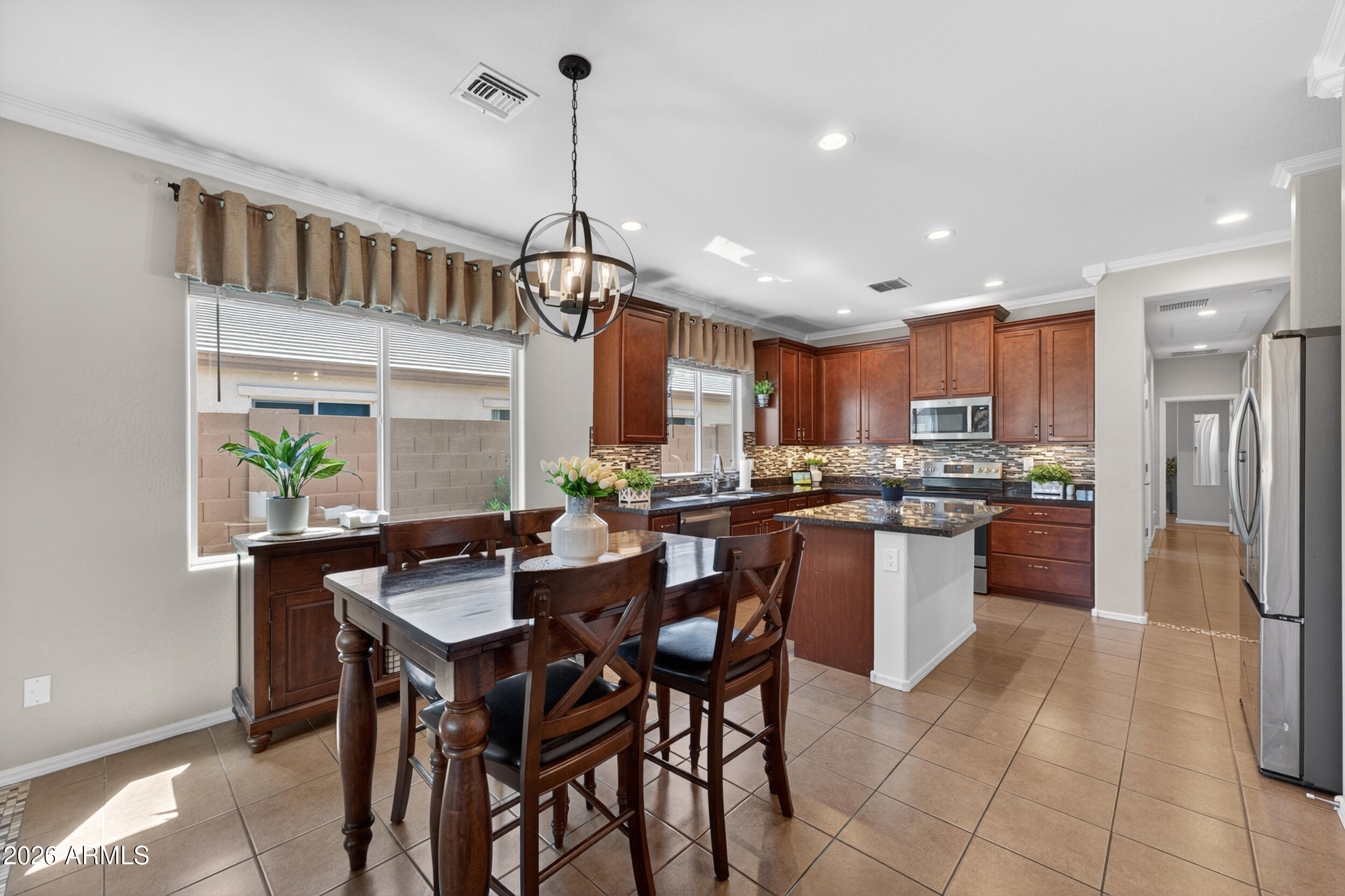 18612 West Mountain View Road Waddell, AZ 85355 - Photo 15 of 71 a kitchen with a table and chairs in it