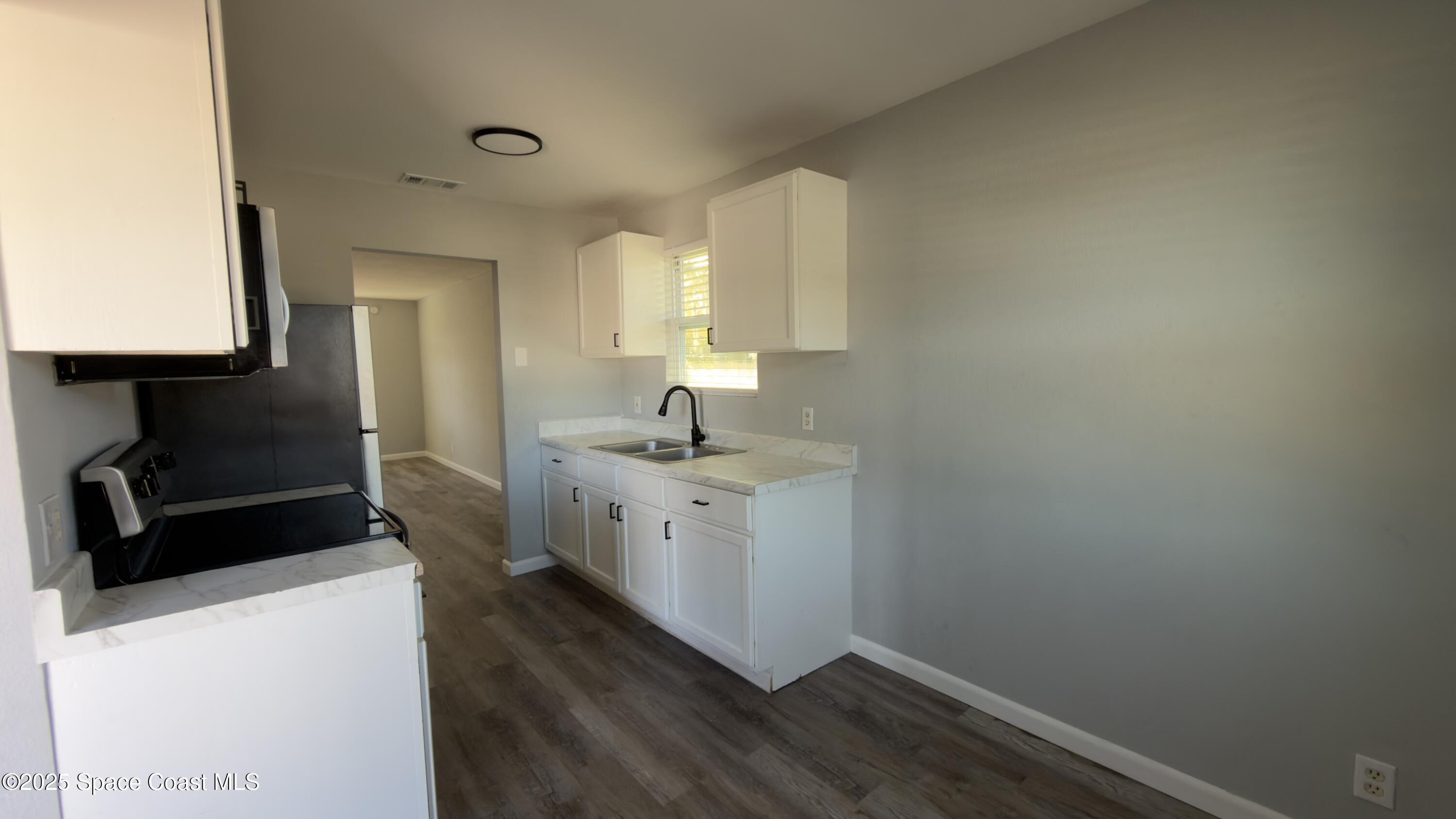 4160 Barna Avenue, Unit C Titusville, FL 32780 - Photo 4 of 14 a room with a sink wooden floor and a window
