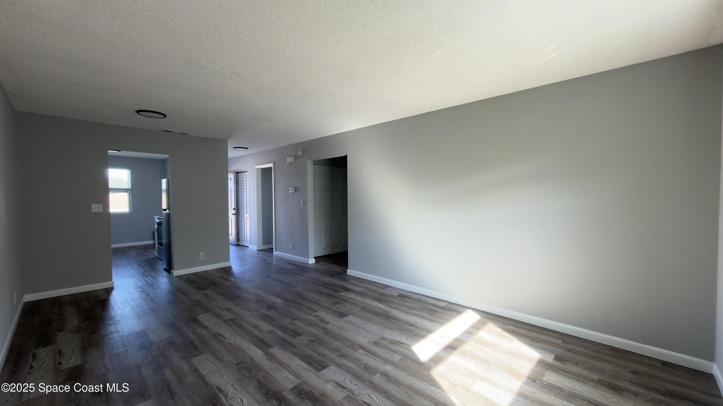 4160 Barna Avenue, Unit C Titusville, FL 32780 - Photo 6 of 14 a view of an empty room with wooden floor and a window