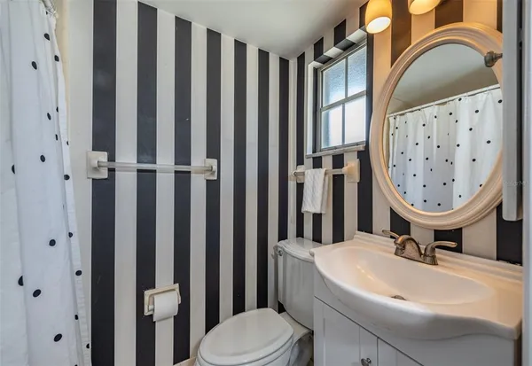 a bathroom with a toilet a sink and a mirror