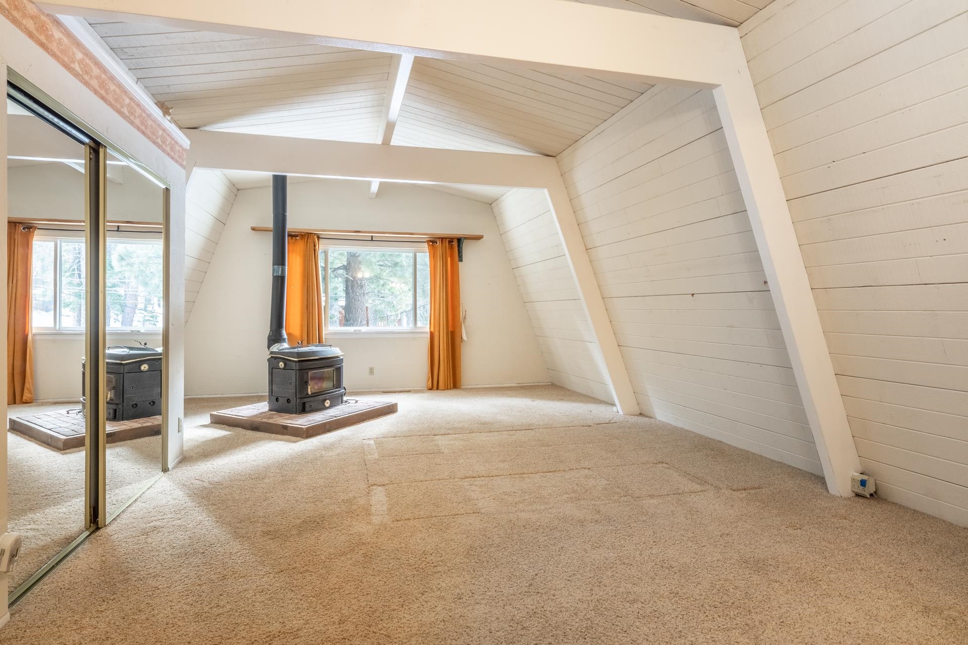 64 Mill Street Mammoth Lakes, CA 93546 - Photo 11 of 27 Primary Suite featuring a wood stove, carpet floors, wooden walls, and wood ceiling